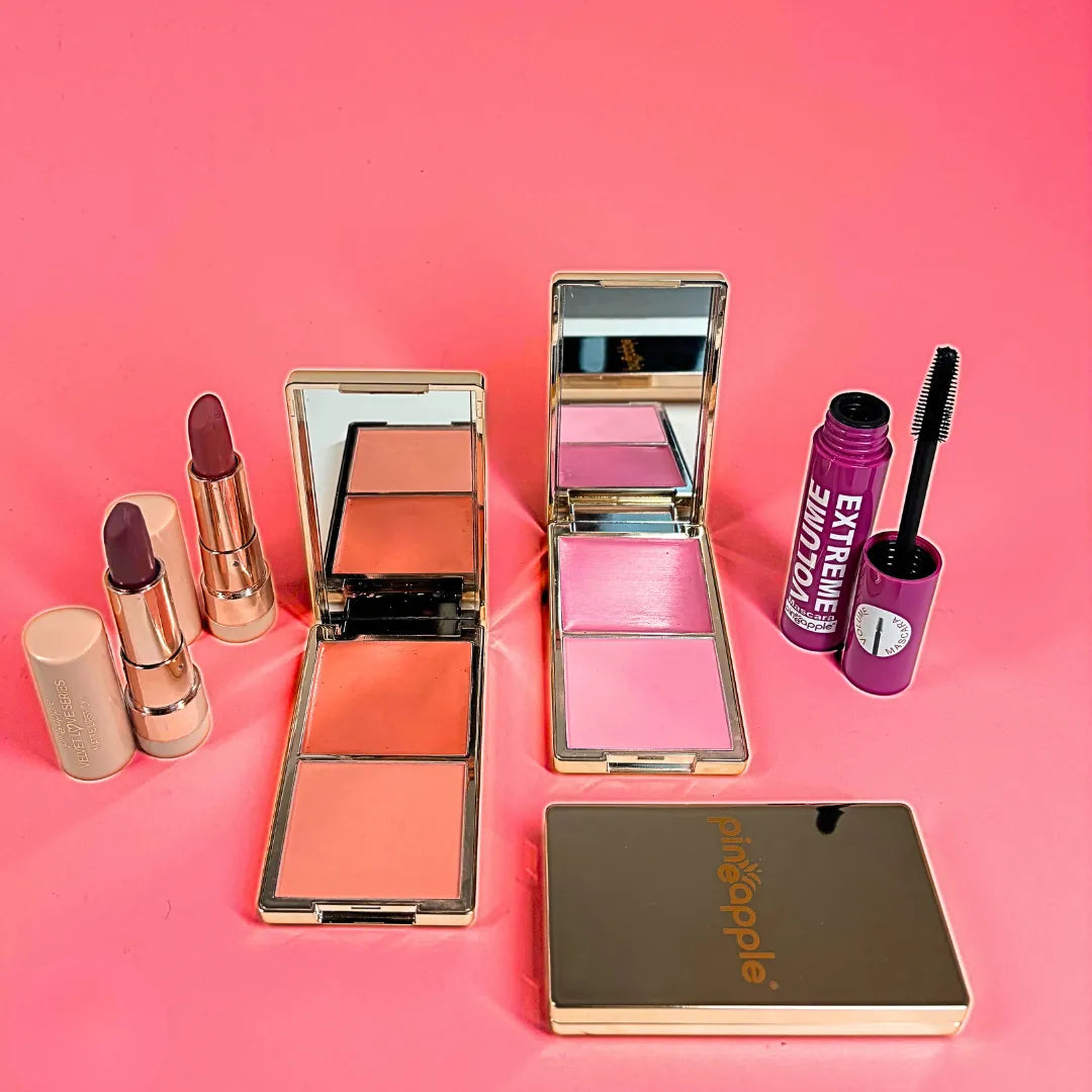 Makeup products including lipsticks, blushes, and a compact mirror on a pink background