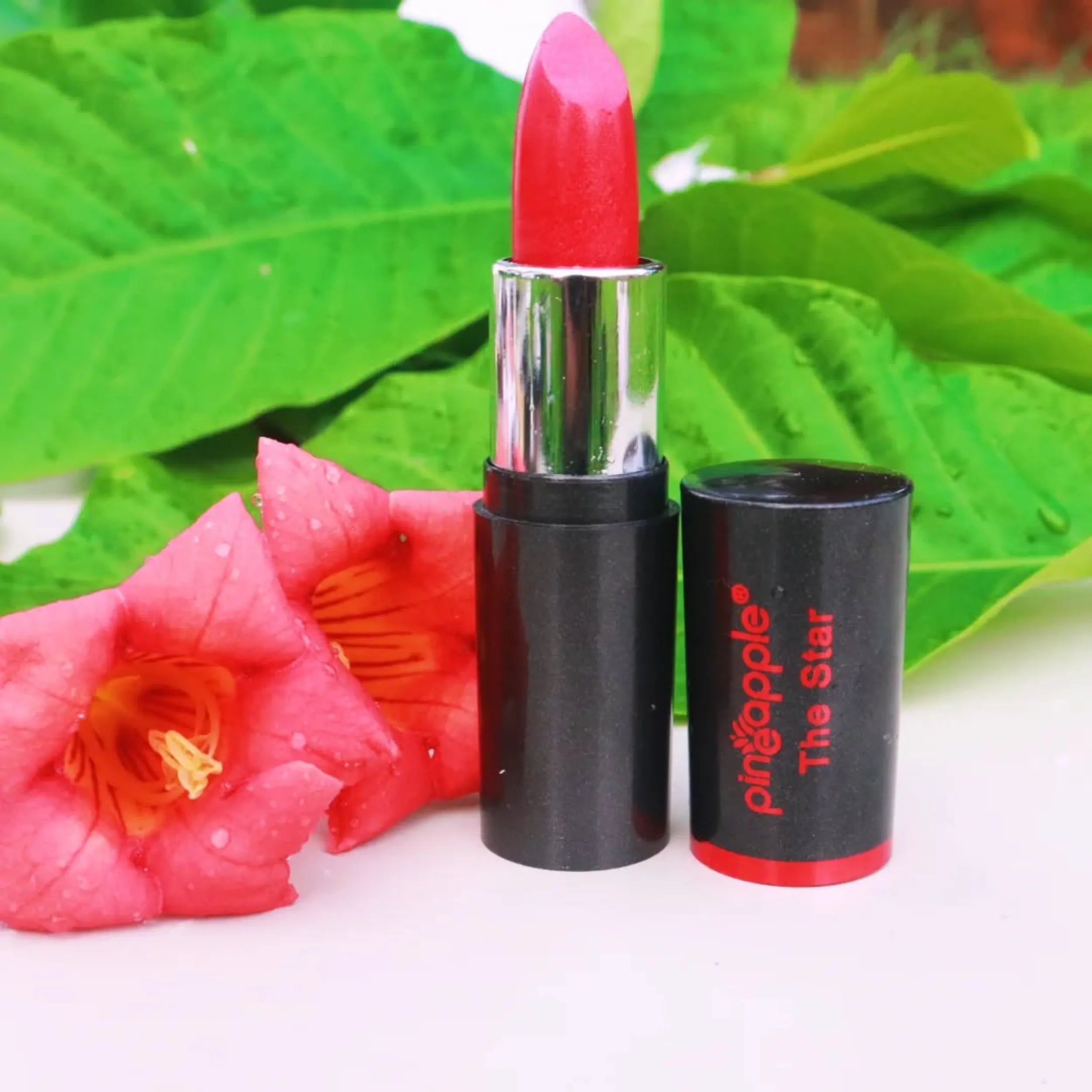 Lipstick sitting next to flower