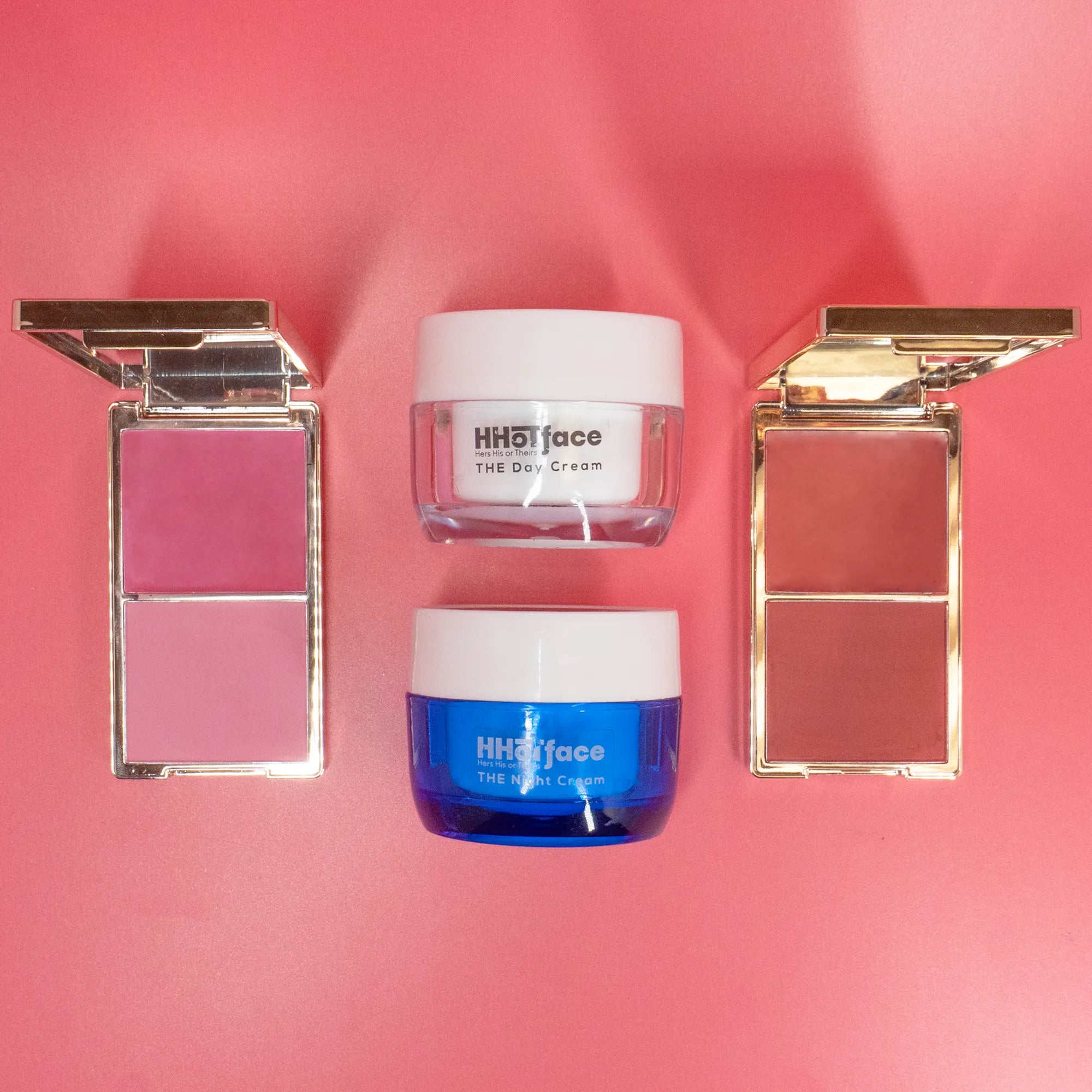 Two jars of face cream and two makeup compact cases on a pink background